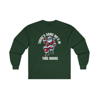 A forest green long sleeve t-shirt featuring a cool Santa Claus wearing sunglasses and dancing. Above him, the bold white text reads "THERE'S SOME HO'S IN," and below, "THIS HOUSE" is written in large white capital letters.