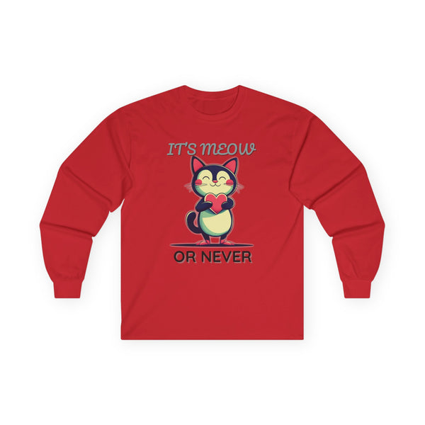 Red long-sleeve Valentine's shirt featuring an adorable cat-themed design. The front showcases a cute black and white cartoon cat with rosy cheeks, holding a red heart and smiling sweetly. Above and below the cat, playful text reads "IT'S MEOW OR NEVER" in a fun, romantic font. This cat lovers' shirt is perfect for Valentine's Day, offering a charming and lighthearted way to celebrate love and affection with a feline twist.